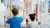 Two kids looking at a science exhibit,  back view