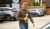 person with a drink and snack, walking to car at a bp fuel station