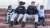 Two police officers in uniform sit on red brick steps with a little girl and little boy